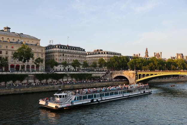 (260622) -- PARIS, June 22, 2026 -- People take a river cruise on the Seine River in Paris, France, June 21, 2026. France celebrated its annual Fete de la Musique (music day) on Sunday. Amid hot weather, many residents and tourists gathered along the banks of the Seine River in Paris to relax and escape the heat. ) FRANCE-PARIS-SUMMER-DAILY LIFE WuxHuiwo 