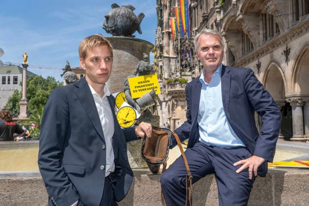 Oberbürgermeister Dominik Krause, Die Grünen, und Stadtkämmerer Christoph Frey, (rechts), zeigen am Fischbrunnen symbolisch die leere Stadtkasse her, beim bundesweiten Aktionstag Kommunalfinanzen, Münchner Aktion 5 vor 12, München, 22. Juni 2026 Deutschland, München, 22. Juni 2026, Oberbürgermeister Dominik Krause, Die Grünen, und Stadtkämmerer Christoph Frey, (rechts), zeigen am Fischbrunnen symbolisch die leere Stadtkasse her, beim bundesweiten Aktionstag Kommunalfinanzen, Münchner Aktion 5 vor 12, wollen damit auf die dramatische kommunale Finanzsituation aufmerksam machen, Finanzlage der Städte, Landkreise und Gemeinden ist dramatisch, hohe Defizite und Schulden in den Haushalten, der Aktionstag wird vom Deutschen Städtetag,