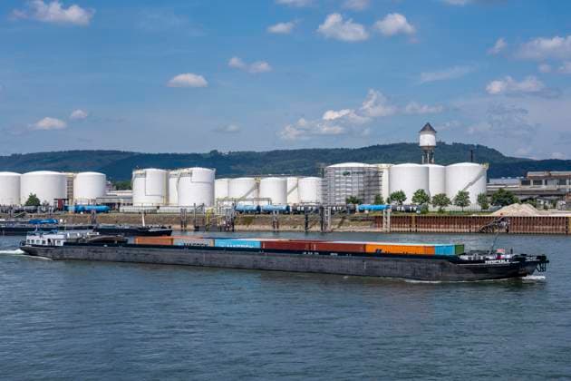 Frachtschiff auf dem Rhein, Höhe Bendorf, im Kreis Mayen-Koblenz, rechtsrheinisch, Tanklager der enport GmbH, 22 Großtanks, hauptschädlich für Kraftstoffe, Rheinland-Pfalz, Deutschland, Tanklager *** Cargo ship on the Rhine, near Bendorf, in the Mayen-Koblenz district, on the right bank of the Rhine, enport GmbH tank farm, 22 large tanks, primarily used for fuels, Rhineland-Palatinate, Germany, tank farm,detected_source_language