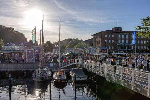 22.06.2026 Kieler Woche 2026 Eindrücke und Szenen vom Montag Abendstimmung bei den Fischbuden an der Kiellinie in Höhe Reventloubrücke. Rechts die Gebäude der Landesregierung Kiel Kiellinie Schleswig Holstein Deutschland *** June 22, 2026 Kiel Week 2026 Impressions and scenes from Monday evening at the fish stands along the Kiellinie near the Reventlou Bridge. On the right are the buildings of the state government in Kiel. Kiellinie, Schleswig-Holstein, Germany,detected_source_language