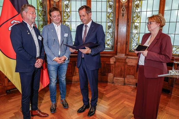 Verleihung der Niedersächsischen Sportmedaille: Ministerpräsident Lies und Sportministerin Behrens ehren niedersächsische Athletinnen und Athleten (v.l.n.r.) Lars Kruckenberg, Resortleiter Sport, Turn- und Sportverein Algesdorf e.V., Rodenberg; Felix Kruckenberg, Resortleiter Kommunikation, Turn- und Sportverein Algesdorf e.V., Rodenberg, Olaf Lies (SPD), Ministerpräsident Niedersachsen liest den Text in der Urkunde der Auszeichnung mit der Niedersächsischen Sportmedaille in der Kategorie Beispielhafte Vereinsarbeit vor, Daniela Behrens (SPD) - Ministerin für Inneres, Sport und Digitalisierung hält die Sportmedaille in den Händen 30175 Hannover, Lüerstraße 5 Gästehaus der Niedersächsische Niedersachsen, Region Hannover Germany