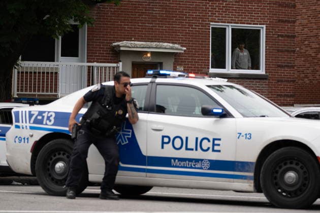 June 22, 2026, Montreal, Canada: A person looks out of a window as police respond to a shooting in the Cote-des-Neiges district of Montreal on Monday. Two people are dead after a suspect opened fire Monday at a Montreal hotel. Montreal Canada  - ZUMAc35_ 20260622_zaf_c35_072 Copyright: xChristopherxKatsarovx