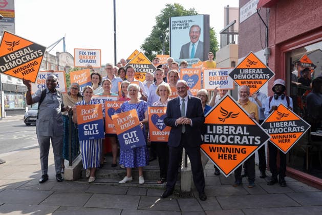 June 23, 2026, London, London, UK: London, UK. Liberal Democrat leader Ed Davey, party MPs and activists stand in front of a digital billboard in Fulham, London, during the launch of a new national campaign targeting Reform UK leader Nigel Farage and highlighting a Â£5 million gift he received, as the party marks the 10th anniversary of the Brexit referendum with the launch of its nationwide billboard campaign. London UK  - ZUMAl94_ 20260623_zaf_l94_014 Copyright: xDinendraxHariax