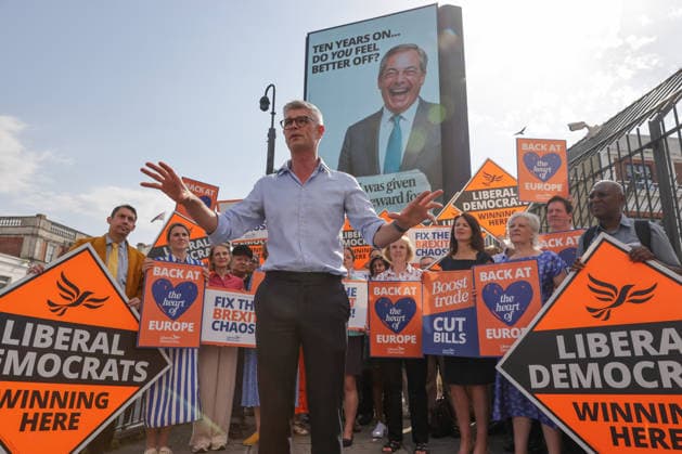 June 23, 2026, London, London, UK: London, UK. Dr Al Pinkerton, Liberal Democrat MP for Surrey Heath, addresses party MPs and activists in front of a digital billboard in Fulham, London, during the launch of the party s new national campaign targeting Reform UK leader Nigel Farage and highlighting a Â£5 million gift he received, as the party marks the 10th anniversary of the Brexit referendum with the launch of its nationwide billboard campaign. London UK  - ZUMAl94_ 20260623_zaf_l94_019 Copyright: xDinendraxHariax
