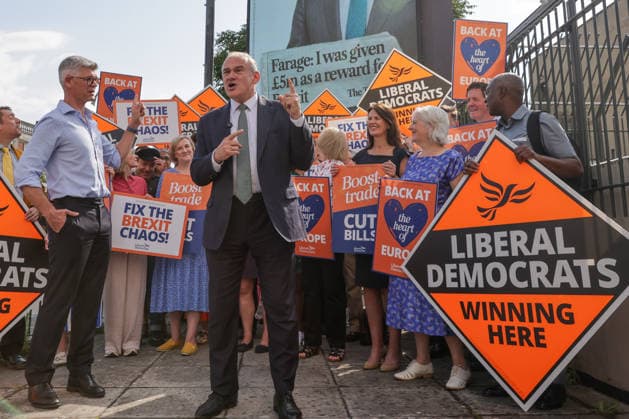 June 23, 2026, London, London, UK: London, UK. Liberal Democrat leader Ed Davey addresses party MPs and activists in front of a digital billboard in Fulham, London, during the launch of a new national campaign targeting Reform UK leader Nigel Farage and highlighting a Â£5 million gift he received, as the party marks the 10th anniversary of the Brexit referendum with the launch of its nationwide billboard campaign. London UK  - ZUMAl94_ 20260623_zaf_l94_025 Copyright: xDinendraxHariax