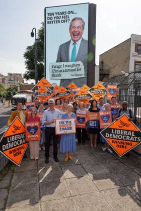 June 23, 2026, London, London, UK: London, UK. Liberal Democrat party MPs and activists in front of a digital billboard in Fulham, London, during the launch of a new national campaign targeting Reform UK leader Nigel Farage and highlighting a Â£5 million gift he received, as the party marks the 10th anniversary of the Brexit referendum with the launch of its nationwide billboard campaign. London UK  - ZUMAl94_ 20260623_zaf_l94_030 Copyright: xDinendraxHariax