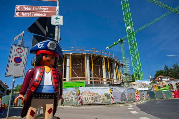 23.06.2026, Bad Wörishofen (Unterallgäu), Baustelle Löwenbräu-Arkaden Bad Wörishofen, der Neubau der Firma Glass aus Mindelheim kommt zügig voran, das Untergeschoss ist schon gut zu erkennen mit dem Rundbau und er Säulenarchitektur für die Terasse. Neben Wohnungen und Gastronomie und Tiefgaragen entsteht ein Ort der Begegnung im Herzen von Bad Wörishofen. Links eine große Playmobilfigur vom nahen Spielwarengeschäft. 23.06.2026, Bad Wörishofen 23.06.2026, Bad Wörishofen *** June 23, 2026, Bad Wörishofen, Unterallgäu; Löwenbräu Arkaden construction site in Bad Wörishofen
