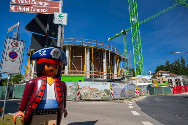 23.06.2026, Bad Wörishofen (Unterallgäu), Baustelle Löwenbräu-Arkaden Bad Wörishofen, der Neubau der Firma Glass aus Mindelheim kommt zügig voran, das Untergeschoss ist schon gut zu erkennen mit dem Rundbau und er Säulenarchitektur für die Terasse. Neben Wohnungen und Gastronomie und Tiefgaragen entsteht ein Ort der Begegnung im Herzen von Bad Wörishofen. Links eine große Playmobilfigur vom nahen Spielwarengeschäft. 23.06.2026, Bad Wörishofen 23.06.2026, Bad Wörishofen *** June 23, 2026, Bad Wörishofen, Unterallgäu; Löwenbräu Arkaden construction site in Bad Wörishofen