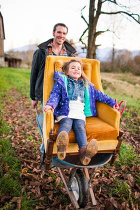 Father pushes daughter in armchair in a wheelbarrow Chilliwack, British Columbia, Canada CR_JDIP260617A3-2055811-01 ,model released, Symbolfoto