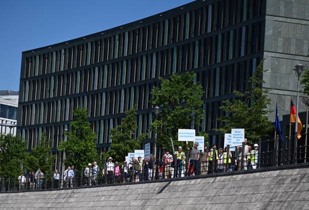 Cargo ship blocks Spree River during rally in Berlin BERLIN, GERMANY - JUNE 24: Participants gather on the banks of the Spree River as a cargo ship blocks the waterway in front of the Reichstag building during a rally organized by MIRO, the German minerals and aggregates industry association, in Berlin, Germany, on June 24, 2026. An 80-meter cargo ship loaded with construction aggregates blocked traffic on the Spree River while demonstrators called for stronger legal protection of mineral deposits and greater consideration of domestic mineral resource extraction and processing in spatial planning legislation. Volodymyr Sindieiev Anadolu Berlin Germany. Editorial use only. Please get in touch for any other usage.  Copyright: x2026xAnadoluxVolodymyrxSindieievx