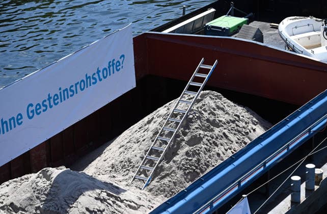 Cargo ship blocks Spree River during rally in Berlin BERLIN, GERMANY - JUNE 24: Construction aggregates are seen aboard a cargo ship blocking the Spree River in front of the Reichstag building during a demonstration organized by MIRO, the German minerals and aggregates industry association, in Berlin, Germany, on June 24, 2026. The vessel, loaded with mineral raw materials, was used as part of a protest calling for stronger legal protection of mineral deposits and greater consideration of domestic resource extraction in spatial planning legislation. Volodymyr Sindieiev Anadolu Berlin Germany. Editorial use only. Please get in touch for any other usage.  Copyright: x2026xAnadoluxVolodymyrxSindieievx