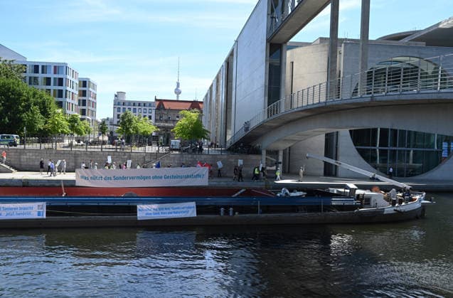 Cargo ship blocks Spree River during rally in Berlin BERLIN, GERMANY - JUNE 24: Participants gather on the banks of the Spree River as a cargo ship blocks the waterway in front of the Reichstag building during a rally organized by MIRO, the German minerals and aggregates industry association, in Berlin, Germany, on June 24, 2026. An 80-meter cargo ship loaded with construction aggregates blocked traffic on the Spree River while demonstrators called for stronger legal protection of mineral deposits and greater consideration of domestic mineral resource extraction and processing in spatial planning legislation. Volodymyr Sindieiev Anadolu Berlin Germany. Editorial use only. Please get in touch for any other usage.  Copyright: x2026xAnadoluxVolodymyrxSindieievx