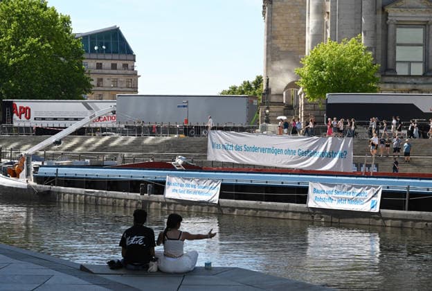 Cargo ship blocks Spree River during rally in Berlin BERLIN, GERMANY - JUNE 24: Participants gather on the banks of the Spree River as a cargo ship blocks the waterway in front of the Reichstag building during a rally organized by MIRO, the German minerals and aggregates industry association, in Berlin, Germany, on June 24, 2026. An 80-meter cargo ship loaded with construction aggregates blocked traffic on the Spree River while demonstrators called for stronger legal protection of mineral deposits and greater consideration of domestic mineral resource extraction and processing in spatial planning legislation. Volodymyr Sindieiev Anadolu Berlin Germany. Editorial use only. Please get in touch for any other usage.  Copyright: x2026xAnadoluxVolodymyrxSindieievx