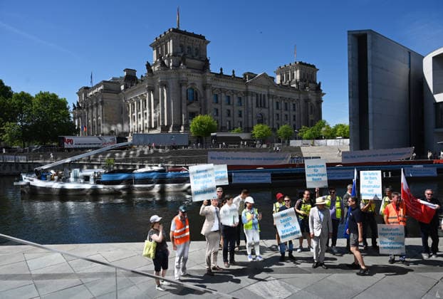 Cargo ship blocks Spree River during rally in Berlin BERLIN, GERMANY - JUNE 24: Participants gather on the banks of the Spree River as a cargo ship blocks the waterway in front of the Reichstag building during a rally organized by MIRO, the German minerals and aggregates industry association, in Berlin, Germany, on June 24, 2026. An 80-meter cargo ship loaded with construction aggregates blocked traffic on the Spree River while demonstrators called for stronger legal protection of mineral deposits and greater consideration of domestic mineral resource extraction and processing in spatial planning legislation. Volodymyr Sindieiev Anadolu Berlin Germany. Editorial use only. Please get in touch for any other usage.  Copyright: x2026xAnadoluxVolodymyrxSindieievx