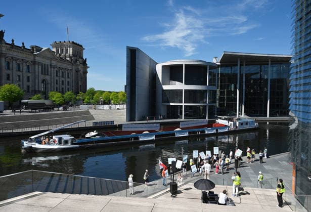 Cargo ship blocks Spree River during rally in Berlin BERLIN, GERMANY - JUNE 24: Participants gather on the banks of the Spree River as a cargo ship blocks the waterway in front of the Reichstag building during a rally organized by MIRO, the German minerals and aggregates industry association, in Berlin, Germany, on June 24, 2026. An 80-meter cargo ship loaded with construction aggregates blocked traffic on the Spree River while demonstrators called for stronger legal protection of mineral deposits and greater consideration of domestic mineral resource extraction and processing in spatial planning legislation. Volodymyr Sindieiev Anadolu Berlin Germany. Editorial use only. Please get in touch for any other usage.  Copyright: x2026xAnadoluxVolodymyrxSindieievx