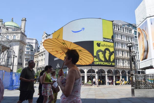 June 24, 2026, London, England, United Kingdom: A woman shelters under an umbrella from the scorching sun in Piccadilly Circus as the Met Office issues an amber warning for extreme heat. London United Kingdom  - ZUMAv130 20260624_zip_v130_030 Copyright: xVukxValcicx