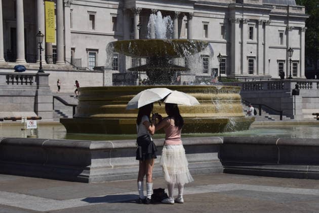 June 24, 2026, London, England, United Kingdom: Women shelter under an umbrella from the scorching sun in Trafalgar Square as the Met Office issues an amber warning for extreme heat. London United Kingdom - ZUMAv130 20260624_zip_v130_034 Copyright: xVukxValcicx