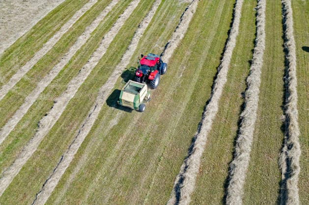 Luftaufnahme. Heuernte im Siegerland. Ein Traktor mit Heuballenpresse ist bei Sonnenschein auf einer gemaehten (gemähten) Wiese bei Siegen-Oberschelden unterwegs. Sommer im Siegerland am 24.06.2026 in Siegen Deutschland. *** Aerial view of hay harvest in the Siegerland region. A tractor equipped with a hay baler is driving across a mowed meadow near Siegen and Oberschelden on a sunny day. Summer in the Siegerland region on June 24, 2026, in Siegen, Germany.