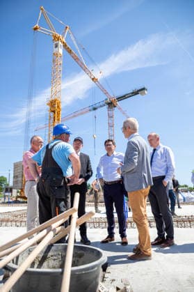 Dr. Andreas Kerath (Vizepräsident der Greifswalder Bürgerschaft li.), der Minister für Inneres und Bau Christian Pegel (3.v.l.), Nicolas Gibert-Morin (Europäische Kommission), Oberbürgermeister Dr. Stefan Fassbinder und Baudezernent Achim Lerm im Gespräch mit einem Vorarbeiter GER, Grundsteinlegung, Inklusives Schulzentrum Am Ellernholzteich, Greifswald, Schule, Hochbau, Schulbau, Neubau, Zeitkapsel *** Dr. Andreas Kerath, Vice President of the Greifswald City Council (left), Christian Pegel, Minister of the Interior and Construction (third from left), Nicolas Gibert Morin of the European Commission, Mayor Dr. Stefan Fassbinder, and Head of the Building Department Achim Lerm in conversation with a foreman from GER; groundbreaking