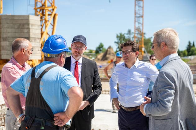 Dr. Andreas Kerath (li.), Minister für Inneres und Bau Christian Pegel (3.v.l.), Nicolas Gibert-Morin (Europäische Kommission) und Oberbürgermeister Dr. Stefan Fassbinder im Gespräch mit einem Vorarbeiter GER, Grundsteinlegung, Inklusives Schulzentrum Am Ellernholzteich, Greifswald, Schule, Hochbau, Schulbau, Neubau, Zeitkapsel *** Dr. Andreas Kerath (left), Minister of the Interior and Construction; Christian Pegel (third from left), Nicolas Gibert Morin of the European Commission and Mayor Dr. Stefan Fassbinder in conversation with a foreman from GER; groundbreaking ceremony; Inclusive School Center Am Ellernholzteich, Greifswald; school; building construction; school construction; new construction; time capsule
