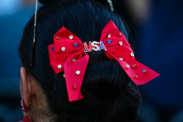 An attendee wears a USA themed hair bow before President Donald Trump speaks at a rally to kick off the 16-day Great American State Fair as part of Washington, D.C. s celebration of the nation s 250th birthday on the National Mall on Wednesday, June 24, 2026. The rally will include military flyovers, musical performances from Lee Greenwood and Christopher Macchio, and the U.S. Army Band, the U.S. Marine Band and Armed Forces choirs.  WAP20260624341 BONNIExCASH