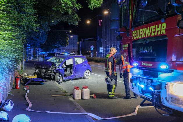 Zwei Männer starben bei schwerem Autounfall in Wuppertal Mit einem Großaufgebot rückte die Wuppertaler Feuerwehr am Mittwochabend (24.06.2026) gegen 22:45 Uhr zur Briller Straße im Stadtteil Elberfeld aus. Vor Ort hatten Augenzeugen einen schweren Verkehrsunfall gemeldet, ein PKW sollte nach ersten Meldungen vor eine Mauer geprallt sein. Als die ersten Retter vor Ort eintrafen bestätigte sich das Bild, ein zerstörter Hyundai I10 stand auf dem Bürgersteig an einer Mauer. Beide Insassen waren im Fahrzeug eingeklemmt, lagen leblos in dem blauen Kleinwagen. Sofort wurde eine umfangreiche Menschenrettung durch die Feuerwehr eingeleitet und die beiden Insassen befreit. Der Rettungsdienst begann unmittelbar mit der Reanimation der beiden M