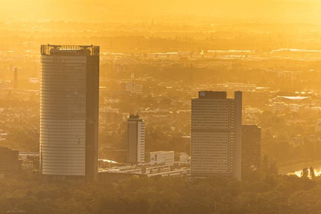 Sonnenuntergang in der Bonn Blick vom Petersberg im Siebengebirge auf Bonn bei Sonnenuntergang: Post Tower und die Hochhäuser des UN-Campus ragen aus dem goldenen Hitze-Dunst. Der Rhein mit einem Frachtschiff spiegelt das warme Abendlicht. Sommerhitze mit bis zu 35 Grad. Königswinter Petersberg Nordrhein-Westfalen Deutschland *** Sunset in Bonn: View of Bonn from Petersberg in the Siebengebirge at sunset; the Post Tower and the skyscrapers of the UN Campus rise above the golden haze of the heat; the Rhine, with a cargo ship, reflects the warm evening light; summer heat reaching up to 35 degrees; Königswinter, Petersberg, North Rhine-Westphalia Germany Copyright: xMarcxJohnx