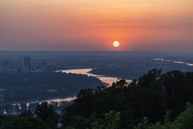 Sonnenuntergang in der Bonn Blick vom Petersberg im Siebengebirge auf Bonn bei Sonnenuntergang: Post Tower und die Hochhäuser des UN-Campus ragen aus dem goldenen Hitze-Dunst. Der Rhein mit einem Frachtschiff spiegelt das warme Abendlicht. Sommerhitze mit bis zu 35 Grad. Königswinter Petersberg Nordrhein-Westfalen Deutschland *** Sunset in Bonn: View of Bonn from Petersberg in the Siebengebirge at sunset; the Post Tower and the skyscrapers of the UN Campus rise above the golden haze of the heat; the Rhine, with a cargo ship, reflects the warm evening light; summer heat reaching up to 35 degrees; Königswinter, Petersberg, North Rhine-Westphalia Germany Copyright: xMarcxJohnx