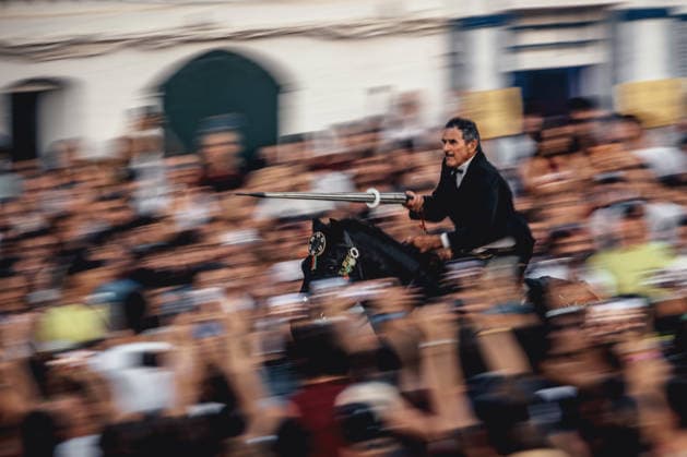 June 24, 2026, Ciutadella, Menorca Balearic Islands, Spain: A caixer (horseman) aims his spear at a suspended ring as he gallops through the cheering crowd during the Jocs des Pla (medieval tournament) during the traditional Sant Joan Ciutadella Spain - ZUMAo105 20260624_fap_o105_046 Copyright: xMatthiasxOesterlex