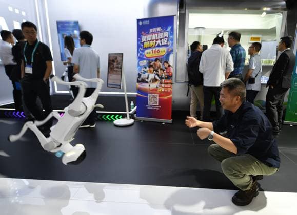 MWC2026 in Shanghai SHANGHAI, CHINA - JUNE 25, 2026 - Viewers watch the intelligent robotic dog s somersault performance at MWC 2206 in Shanghai, China on June 25, 2026. Shanghai Shanghai China  Copyright: xCFOTOx i1782397695084