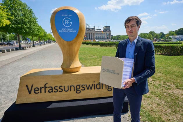 Skulptur-Aktion am Donnerstag (25.06.2026) zum AfD-Gutachten vor dem Bundestag in Berlin. Die AfD ist einem juristischen Gutachten zufolge verfassungswidrig. Sie verstosse gegen das Demokratieprinzip und die Menschenwuerde, heisst es in der Ausarbeitung der Gesellschaft fuer Freiheitsrechte (GFF), die am Donnerstag in Berlin vorgestellt wurde. Die Autorinnen und Autoren halten es fuer wahrscheinlich, dass ein Verbotsantrag gegen die Partei vor dem Bundesverfassungsgericht Erfolg haette. Zur Begruendung verwies Projektleiter Bijan Moini (Foto) unter anderem auf ein rassistisch gepraegtes politisches Konzept der AfD. Die Partei definiere unterschiedliche Klassen von Menschen und werte insbesondere Menschen mit Migrationshintergrund ab. Si Copyright: epd-bild ChristianxDitsch epd-AfD-Gutachten3-kopieren