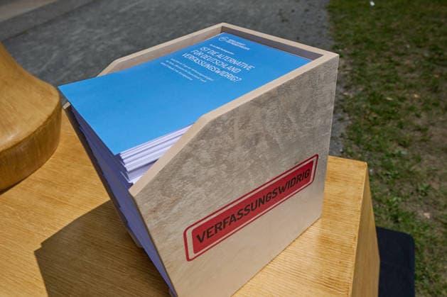 Kopie des Gutachtens mit ueber 1300 Seiten (Foto vom 25.06.2026). Die AfD ist einem juristischen Gutachten zufolge verfassungswidrig. Sie verstosse gegen das Demokratieprinzip und die Menschenwuerde, heisst es in der Ausarbeitung der Gesellschaft fuer Freiheitsrechte (GFF), die am Donnerstag in Berlin vorgestellt wurde. Die Autorinnen und Autoren halten es fuer wahrscheinlich, dass ein Verbotsantrag gegen die Partei vor dem Bundesverfassungsgericht Erfolg haette. Zur Begruendung verwies Projektleiter Bijan Moini unter anderem auf ein rassistisch gepraegtes politisches Konzept der AfD. Die Partei definiere unterschiedliche Klassen von Menschen und werte insbesondere Menschen mit Migrationshintergrund ab. Sie habe ein ethnisch-kulturelle Copyright: epd-bild ChristianxDitsch epd-AfD-Gutachten4-kopieren