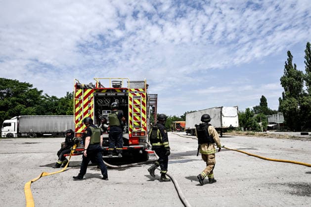Firefighters stay by a fire engine at a parking lot, where a fire broke out due to Russian drone strikes, Zaporizhzhia, Ukraine, June 25, 2026. The Russian army attacked the city with strike drones, targeting a petrol station, Ukrzaliznytsia (Ukrainian Railways) locomotives and a parking lot. Fires broke out, and one person was killed as a result of the attack. (Photo by Dmytro Smolienko Ukrinform) Russia attacks parking lot in Zaporizhzhia with drones  Copyright: xDmytroxSmolienkox