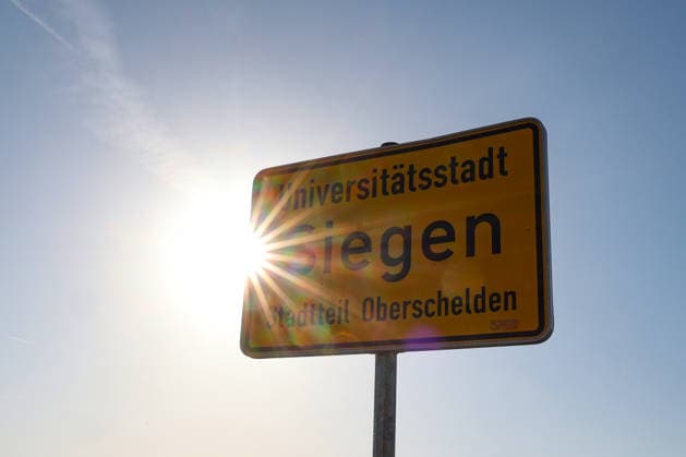 Sommer im Siegerland. Es ist sehr heiss (heiß) und die Temperaturen sollen weiter ansteigen. Der Himmel ist blau und die Sonne strahlt vom wolkenlosen Himmel. Im Vordergrund ein Ortseingangsschild der Universitaetsstadt (Universitätsstadt) Siegen Stadtteil Oberschelden. Sommer am 26.06.2026 in Siegen Deutschland. *** Summer in the Siegerland. It’s very hot, and temperatures are expected to rise further. The sky is blue, and the sun is shining from a cloudless sky. In the foreground is a town sign marking the entrance to the university town of Siegen, in the Oberschelden district. Summer on June 26, 2026, in Siegen, Germany