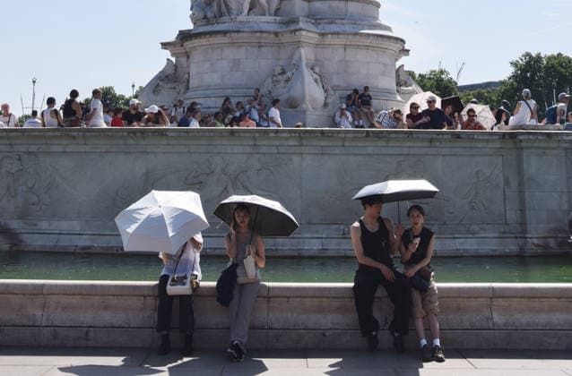 June 26, 2026, London, England, United Kingdom: People shelter under umbrellas from the scorching sun next to the Victoria Memorial outside Buckingham Palace as the Met Office issues an amber warning for extreme heat. London United Kingdom - ZUMAv130 20260626_zip_v130_007 Copyright: xVukxValcicx