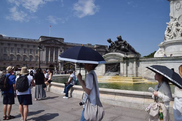 June 26, 2026, London, England, United Kingdom: People shelter under umbrellas from the scorching sun outside Buckingham Palace as the Met Office issues an amber warning for extreme heat. London United Kingdom  - ZUMAv130 20260626_zip_v130_011 Copyright: xVukxValcicx