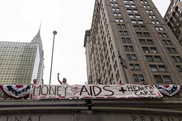 June 26, 2026, New York, New York, USA: Members of ACT UP New York begin Pride weekend with an act of civil disobedience blockading traffic during the morning rush hour on 42nd Street outside Grand Central Station stating solidarity with striking Delaney Hall immigrant detainees and denouncing Trump administration cuts to AIDS funding and healthcare. After traffic is at a standstill for approximately 40 minutes, NYPD arrests demonstrators. The protest banner is Ã¢â‚¬ËœMoney for AIDS and Healthcare Not for ICE and Warfare. Demonstrators defend New YorkÃ¢â‚¬â ¢s sanctuary city status as an ICE surge is promised and protest funding cuts to AIDS Drug Assistance Programs (ADAP,) The U.S. PresidentÃ¢â‚¬â ¢s Emergency Plan for AIDS Relief (PEPFAR - ZUMAr174 20260626_znp_r174_008 Copyright: xGinaxMxRandazzox