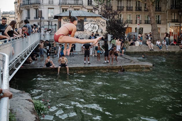 Parisians Swim In The Canal Saint-Martin To Escape The Heatwave A woman performs an acrobatic jump into the Canal Saint-Martin in Paris, France, on June 26, 2026, as people take a dip to cool off during the intense heatwave that has placed the capital under a red alert. Paris France  Copyright: xSamuelxBoivinx originalFilename: boivin-notitle260626_npLpn.jpg