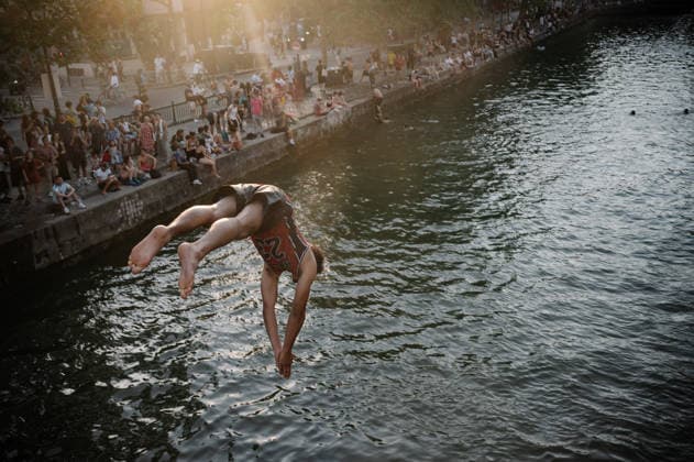 Parisians Swim In The Canal Saint-Martin To Escape The Heatwave A man dives headfirst into the Canal Saint-Martin, hands clasped towards the water, as a crowd watches from the banks in Paris, France, on June 26, 2026. Parisians swim to cool off during the intense heatwave that has placed the capital under a red alert. Paris France  Copyright: xSamuelxBoivinx originalFilename: boivin-notitle260626_npa2s.jpg