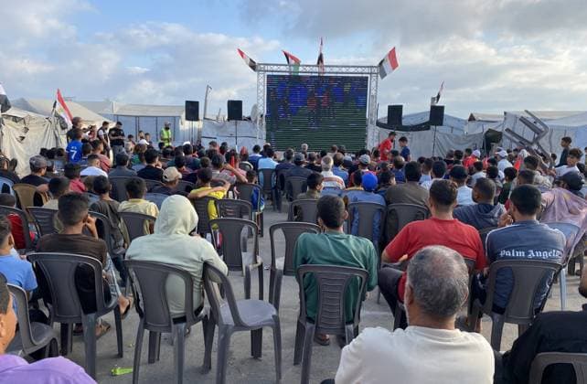 Displaced Palestinians watch World Cup match in Khan Younis camp Displaced Palestinians gather to watch the FIFA World Cup 2026 Group G first-round match between Egypt and Iran on a giant screen set up among displacement tents in Khan Younis, southern Gaza Strip, on June 27, 2026. The public screening provided a brief moment of communal gathering for displaced families living in difficult humanitarian conditions. Photo by Tariq Mohammad APA Images Khan Yunis Gaza Strip Palestinian Territory 270626_Khan_Yunis_TM_01(2).jpeg Copyright: xapaimagesxTariqxMohammad xapaimagesx