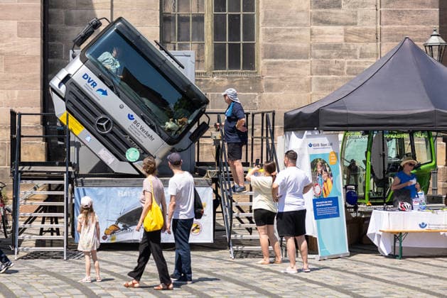14. Landestag der Verkehrssicherheit, Nürnberg, 27.06.2026 Ein LKW-Crashsimulator des DVR (Deutscher Verkehrssicherheitsrat) und der BG Verkehr zeigt Besuchern die Auswirkungen eines Überschlags. Besucher warten vor dem aufgerichteten Mercedes-Lkw auf ihren Einsatz im Simulator. Nürnberg Bayern Deutschland *** 14th State Road Safety Day, Nuremberg, June 27, 2026 A truck crash simulator provided by the DVR (German Road Safety Council) and BG Verkehr demonstrates the effects of a rollover to visitors. Visitors wait in front of the upright Mercedes truck for their turn in the simulator. Nuremberg, Bavaria, Germany 20260627-286A0399-M4000