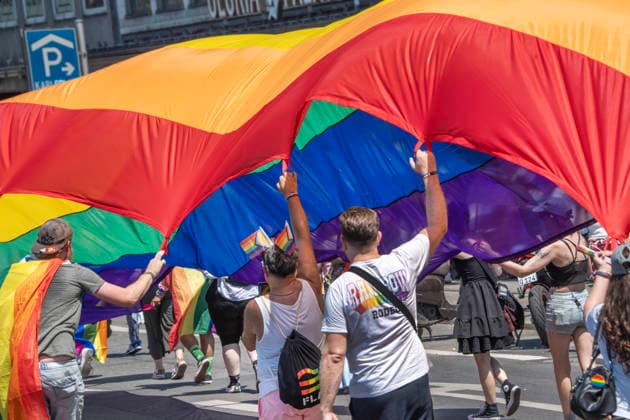 Ausgelassene Stimmung, auch bei den Zuschauern, wie hier auf einem Balkon, mit Regenbogenfahne und pinkem Rauch, CSD 2026, große Politparade, Höhepunkt der Pride Weeks, München, 27. Juni 2026 Deutschland, München, 27. Juni 2026, Teilnehmer PRIDE Ulm Neu-Ulm mit riesiger Regenbogenfahne beim CSD 2026, hier am Stachus, große PolitParade mit Hunderttausenden Zuschauern und Teilnehmern, im Rahmen der Pride Weeks, Motto Unsere Vielfalt. Unsere Stärke., Christopher Street Day, größte Demonstration von Lesben, Schwulen, Bisexuellen, trans*, inter* und queeren Menschen (LGBTIQ*) für gleiche Rechte und gesellschaftliche Akzeptanz im süddeutschen Raum, Demozug quer durch die Münchner Innenstadt von der Erhardstraße über das Sendlinger To