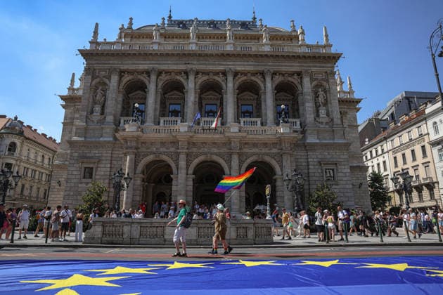News Bilder des Tages June 27, 2026, Budapest, Hungary, European Union: A person holding a pride flag walks in front of the Opera house and past an EU flag on the ground on Andrassy avenue during Budapest Pride, the first Pride march held since HungaryÃ¢â‚¬â ¢s April 2026 parliamentary election. The annual event brought together LGBTQ+ people, allies and supporters calling for equality, visibility and acceptance. Budapest European Union  - ZUMAo116 20260627_znp_o116_063 Copyright: xBiancaxOterox