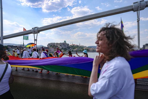 June 27, 2026, Budapest, Hungary, European Union: A young man smiles while walking with a group holding a giant pride flag across the Elizabeth bridge with the Budapest Palace in the background, during Budapest Pride, the first Pride march held since HungaryÃ¢â‚¬â ¢s April 2026 parliamentary election. The annual event brought together LGBTQ+ people, allies and supporters calling for equality, visibility and acceptance. Budapest European Union  - ZUMAo116 20260627_znp_o116_083 Copyright: xBiancaxOterox
