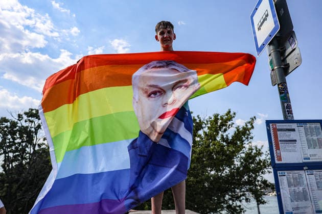June 27, 2026, Budapest, Hungary, European Union: A young man holds a rainbow pride flag with a depiction of former Prime Minister Viktor Orban in makeup on it during Budapest Pride, the first Pride march held since HungaryÃ¢â‚¬â ¢s April 2026 parliamentary election. The annual event brought together LGBTQ+ people, allies and supporters calling for equality, visibility and acceptance. Budapest European Union  - ZUMAo116 20260627_znp_o116_086 Copyright: xBiancaxOterox