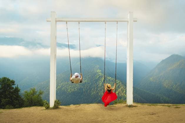 Paar reitet auf einer riesigen Schaukel über einem Gebirgstal mit Wald, Wolken und Panoramalandschaft, die Freiheit, Romantik, Abenteuer, Wellness und Traumreisen symbolisiert Couple riding giant swing above mountain valley with forest, clouds and panoramic landscape, symbolizing freedom, romance, adventure, wellness and dream travel Copyright: imageBROKER EvaldasxMikoliunas ibxemi18169951.jpg ,model released, Symbolfoto ,property released