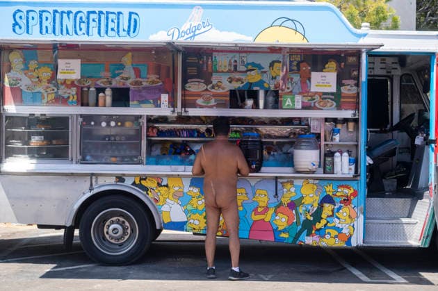 June 27, 2026, Los Angeles, California, USA: A participant in the World Naked Bike Ride buys food from a food truck before the annual ride through downtown Los Angeles on Saturday, June 27, 2026. Los Angeles USA - ZUMAc68_ 20260627_zaf_c68_009 Copyright: xRingoxChiux