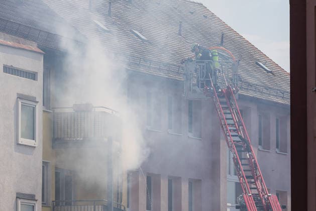 Wohnungsbrand in Mehrfamilienhaus in der Sebalder Altstadt - Spitzberg, Nürnberg, 28.06.2026 Feuerwehreinsatz an einem Mehrfamilienhaus mit starker Rauchentwicklung. Ein Feuerwehrmann arbeitet vom Korb einer Drehleiter aus auf Dachhöhe, während dichter Rauch aus dem Gebäude dringt. Der Einsatz findet bei extremer Sommerhitze von rund 36Â°C statt. *** Apartment Fire in an Apartment Building in the Sebald Old Town of Spitzberg, Nuremberg, June 28, 2026 Fire department response to an apartment building with heavy smoke A firefighter works from the basket of an aerial ladder at roof level while thick smoke billows from the building The operation takes place amid extreme summer heat of around 36°C 20260628-1V9A4609-M4000