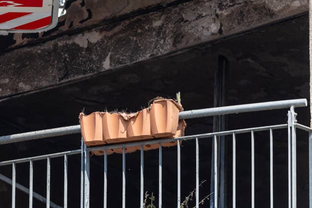 Wohnungsbrand in Mehrfamilienhaus in der Sebalder Altstadt - Spitzberg, Nürnberg, 28.06.2026 Ein Blumenkasten aus Terrakotta liegt beschädigt auf dem Balkongeländer eines Mehrfamilienhauses. Die Fassade im Hintergrund zeigt deutliche Brandspuren und Rußschwärzungen nach einem Feuer bei extremer Sommerhitze von 36Â°C. *** Apartment Fire in an Apartment Building in the Old Town of Sebald, Spitzberg, Nuremberg, June 28, 2026 A damaged terracotta flowerpot lies on the balcony railing of an apartment building. The facade in the background shows clear signs of fire damage and soot stains following a fire during extreme summer heat of 36°C 20260628-1V9A4635-M4000