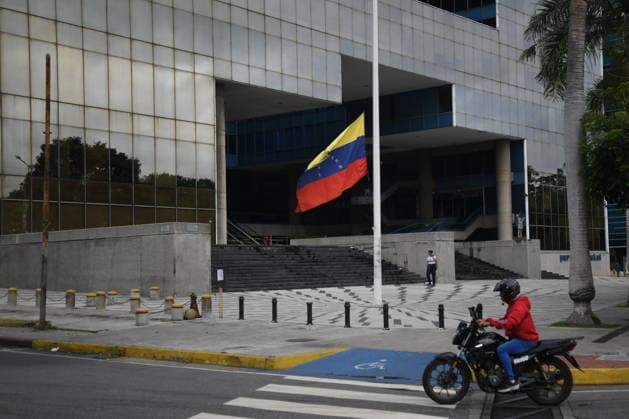 (260629) -- CHACAO, June 29, 2026 -- A motorcyclist rides past a Venezuelan national flag at half-mast in Chacao, Venezuela, on June 28, 2026. Venezuelan National Assembly President Jorge Rodriguez said Sunday that the death toll from two powerful earthquakes that struck Venezuela Wednesday has risen to 1,450. (Photo by Xinhua) (SpotNews) VENEZUELA-CHACAO-EARTHQUAKE-AFTERMATH MarcosxSalgado 